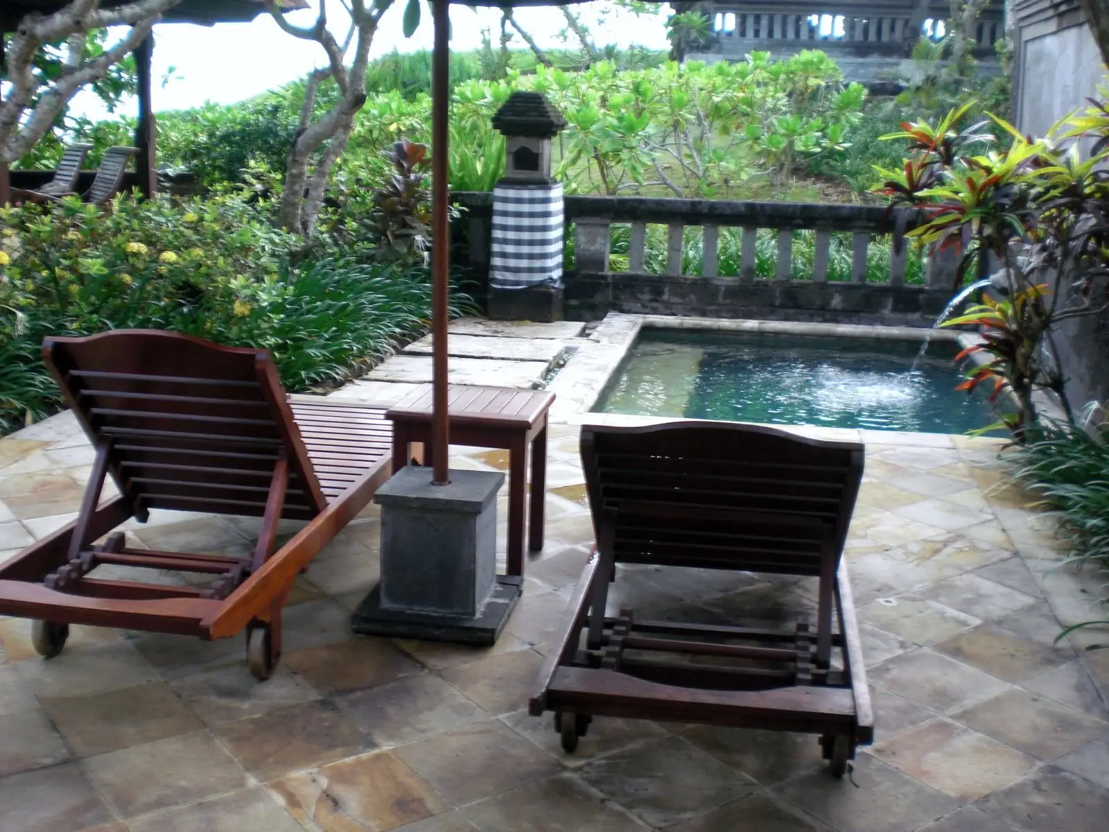 Timber loungers beside a courtyard pool