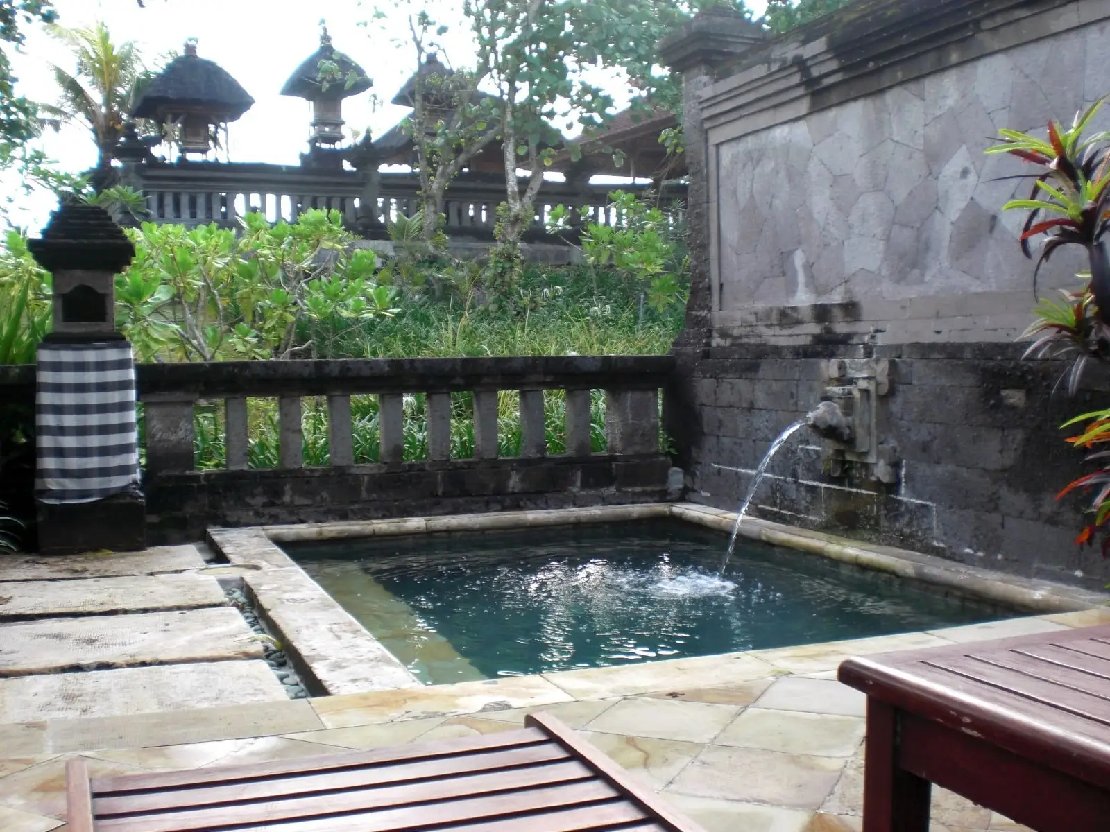 Carved stone fountain feeding a small pool