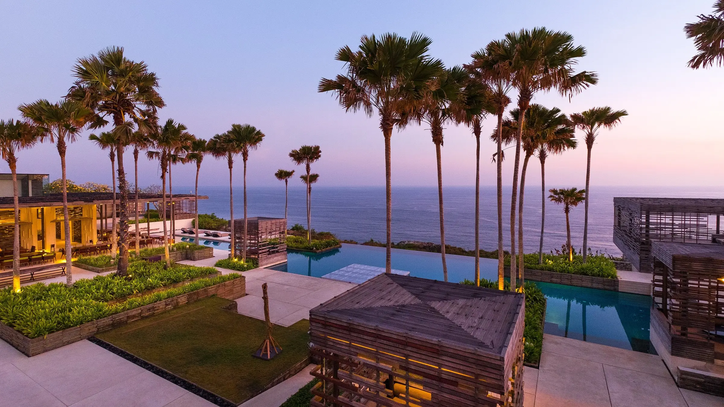 Villas and pools above the ocean at dusk