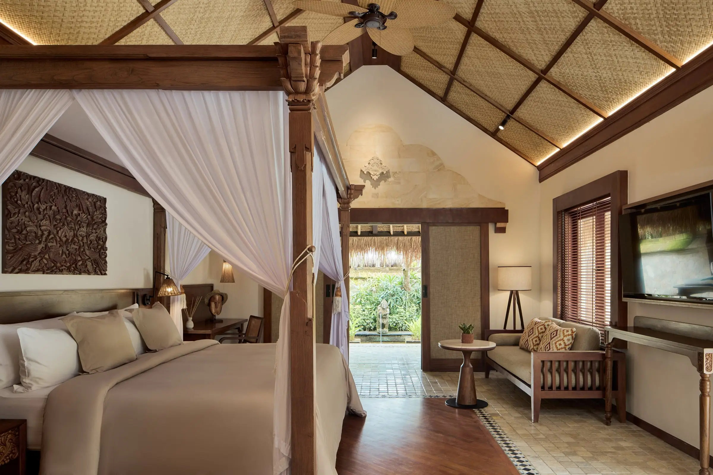 Bedroom with a timber ceiling, carved headboard and garden view